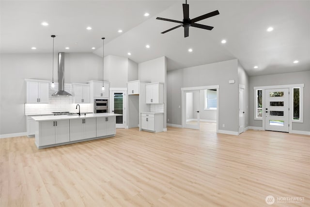 821 174th Ave NW, Lakebay, WA 98349 - kitchen featuring wall chimney range hood, high vaulted ceiling, open floor plan, a spacious island, and tasteful backsplash