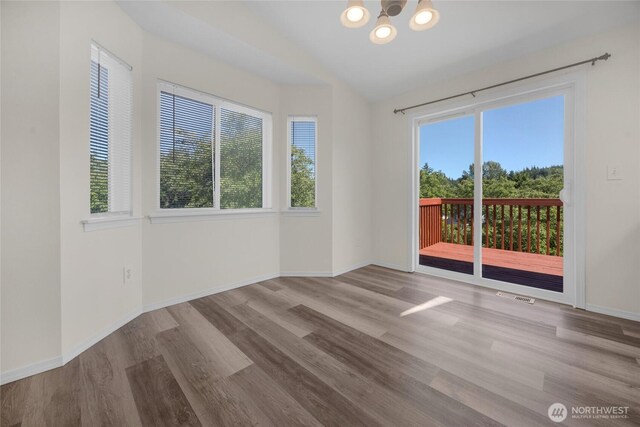 8618 217th Pl NE, Arlington, WA 98223 - spare room featuring plenty of natural light, a chandelier, lofted ceiling, and wood finished floors