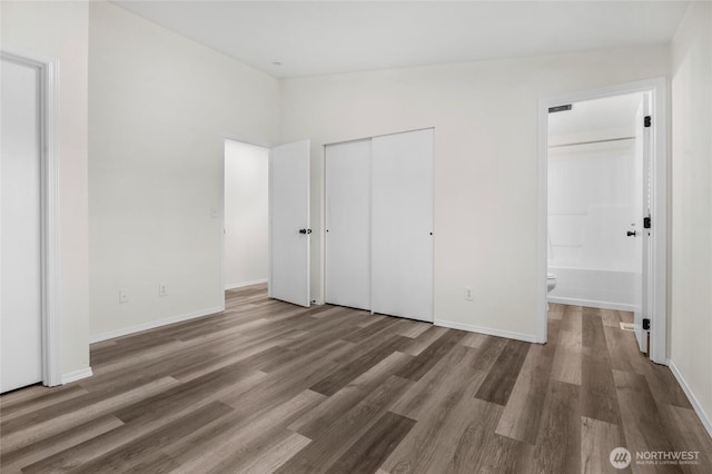 8618 217th Pl NE, Arlington, WA 98223 - unfurnished bedroom featuring wood finished floors, ensuite bathroom, and a closet