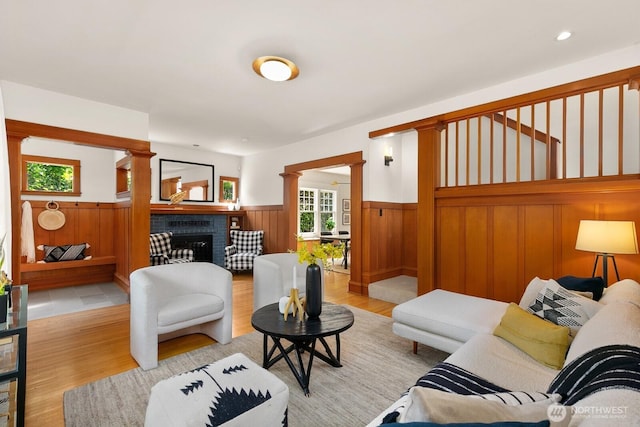 109 E Roanoke St, Seattle, WA 98102 - living room featuring wainscoting, light wood-style floors, a fireplace, and decorative columns