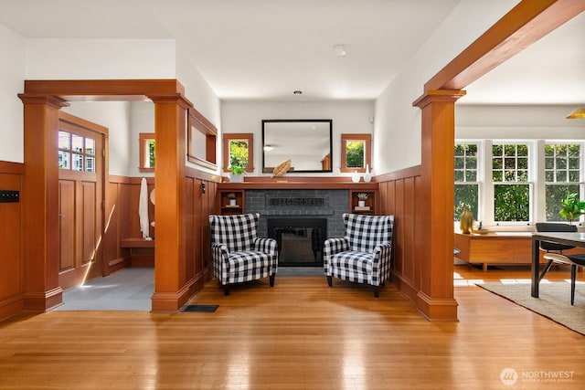 109 E Roanoke St, Seattle, WA 98102 - living area featuring a wainscoted wall, a fireplace, wood finished floors, and healthy amount of natural light
