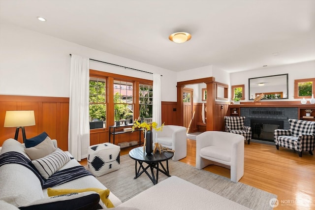 109 E Roanoke St, Seattle, WA 98102 - living area with a wainscoted wall, light wood-style floors, plenty of natural light, and a fireplace