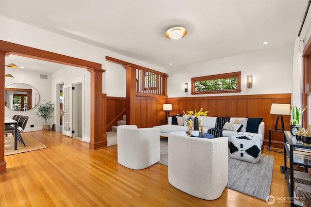 109 E Roanoke St, Seattle, WA 98102 - living area with wainscoting, decorative columns, stairway, light wood-style floors, and recessed lighting