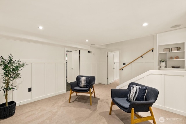 109 E Roanoke St, Seattle, WA 98102 - living area featuring a decorative wall, stairway, light colored carpet, recessed lighting, and wainscoting