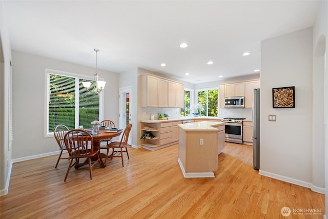 1402 Langara Cir, Bellingham, WA 98229 - kitchen with stainless steel appliances, a kitchen island, light wood-style floors, light countertops, and a chandelier