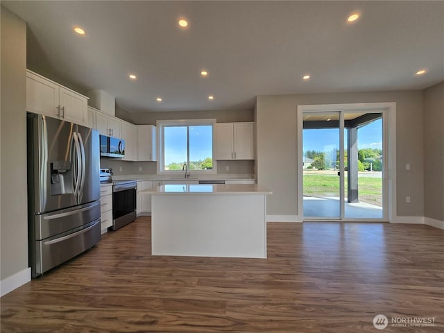 71 Falconcrest Ct, Sequim, WA 98382 - kitchen with stainless steel appliances, light countertops, white cabinets, recessed lighting, and dark wood-type flooring