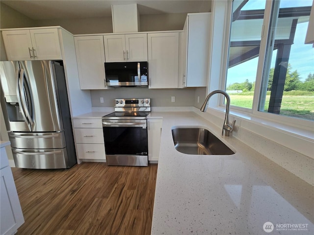 71 Falconcrest Ct, Sequim, WA 98382 - kitchen featuring appliances with stainless steel finishes, white cabinetry, dark wood finished floors, and light stone countertops
