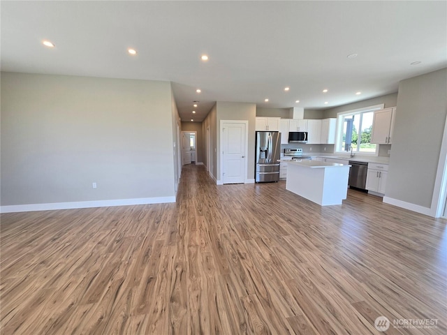 71 Falconcrest Ct, Sequim, WA 98382 - kitchen featuring appliances with stainless steel finishes, open floor plan, a center island, white cabinets, and light countertops