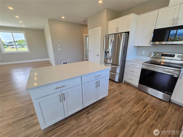 71 Falconcrest Ct, Sequim, WA 98382 - kitchen with appliances with stainless steel finishes, light wood finished floors, white cabinetry, recessed lighting, and a center island