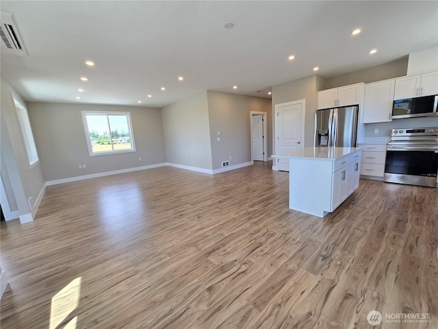 71 Falconcrest Ct, Sequim, WA 98382 - kitchen featuring stainless steel appliances, a center island, open floor plan, recessed lighting, and light wood-type flooring