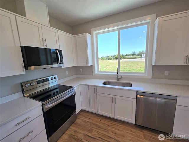 71 Falconcrest Ct, Sequim, WA 98382 - kitchen featuring stainless steel appliances, white cabinetry, wood finished floors, and light countertops