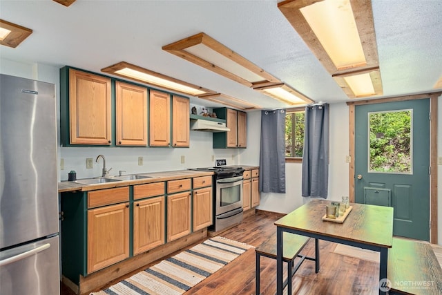 16845 Second Creek Rd, Leavenworth, WA 98826 - kitchen with stainless steel appliances, wood finished floors, light countertops, a textured ceiling, and under cabinet range hood