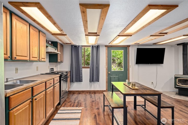 16845 Second Creek Rd, Leavenworth, WA 98826 - kitchen featuring a wood stove, range with electric cooktop, dark wood-type flooring, ventilation hood, and a textured ceiling