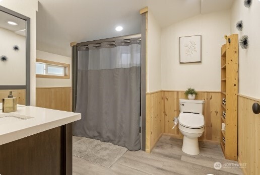 16845 Second Creek Rd, Leavenworth, WA 98826 - bathroom featuring a wainscoted wall, wood finished floors, vanity, a shower with curtain, and wood walls