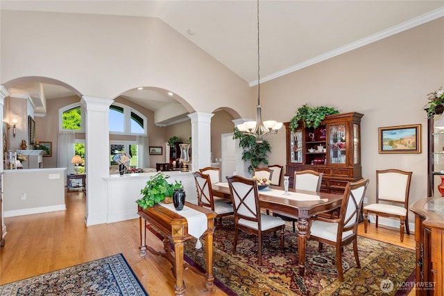 3912 Prestwick Ln SE, Olympia, WA 98501 - dining area featuring decorative columns, arched walkways, light wood-style flooring, a chandelier, and high vaulted ceiling