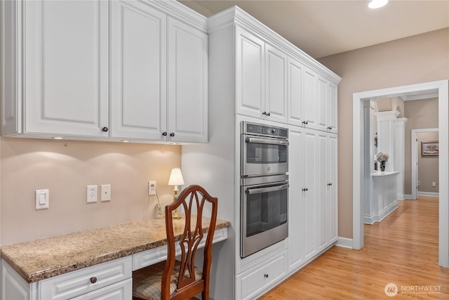 3912 Prestwick Ln SE, Olympia, WA 98501 - kitchen with double oven, built in study area, white cabinetry, light wood-style floors, and recessed lighting