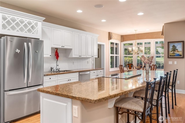 3912 Prestwick Ln SE, Olympia, WA 98501 - kitchen with stainless steel appliances, light wood-style floors, white cabinetry, a chandelier, and recessed lighting