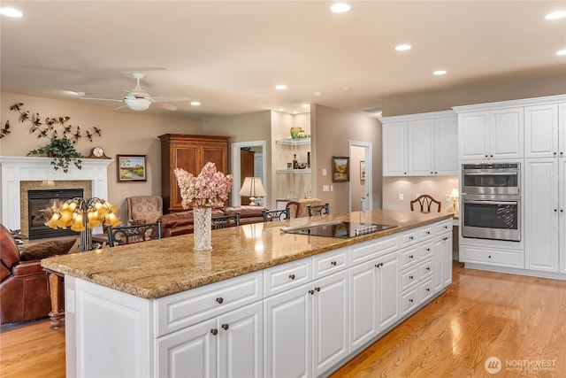 3912 Prestwick Ln SE, Olympia, WA 98501 - kitchen featuring black electric cooktop, open floor plan, light wood finished floors, recessed lighting, and white cabinets