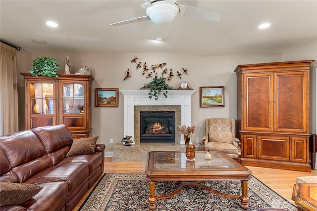 3912 Prestwick Ln SE, Olympia, WA 98501 - living room with light wood-style flooring, a glass covered fireplace, a ceiling fan, and recessed lighting