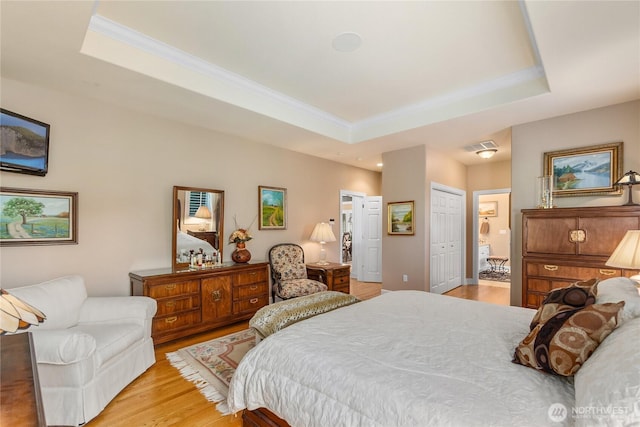 3912 Prestwick Ln SE, Olympia, WA 98501 - bedroom with ornamental molding, a raised ceiling, light wood-type flooring, connected bathroom, and a closet