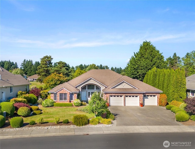 3912 Prestwick Ln SE, Olympia, WA 98501 - single story home with an attached garage, driveway, a front yard, a tiled roof, and brick siding