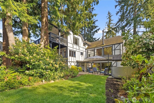 118 NW 132nd St, Seattle, WA 98177 - back of property featuring roof with shingles, a lawn, stucco siding, a patio area, and a balcony