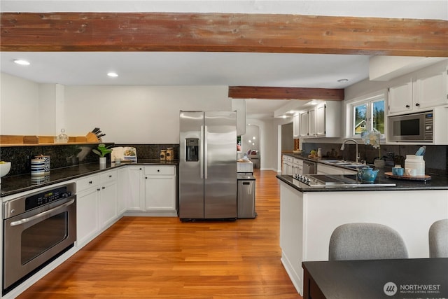 118 NW 132nd St, Seattle, WA 98177 - kitchen featuring stainless steel appliances, light wood-style flooring, dark countertops, white cabinetry, and recessed lighting
