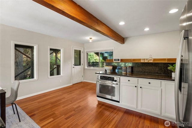 118 NW 132nd St, Seattle, WA 98177 - kitchen featuring stainless steel appliances, wood finished floors, beam ceiling, dark countertops, and white cabinetry