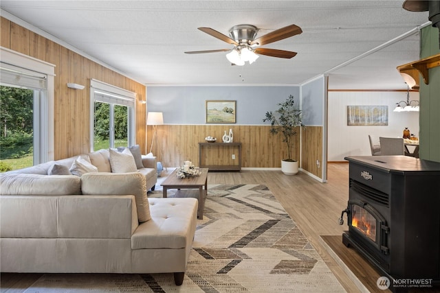 27114 320th Ave SE, Ravensdale, WA 98051 - living area featuring wood walls, ceiling fan, wood finished floors, ornamental molding, and a wood stove