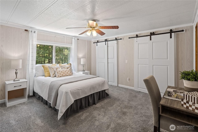 27114 320th Ave SE, Ravensdale, WA 98051 - carpeted bedroom featuring a barn door, a textured ceiling, crown molding, a ceiling fan, and wood walls