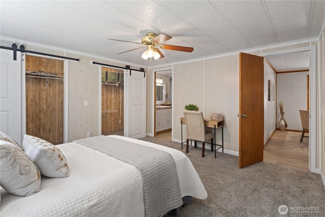 27114 320th Ave SE, Ravensdale, WA 98051 - carpeted bedroom featuring a barn door, crown molding, a ceiling fan, a textured ceiling, and two closets