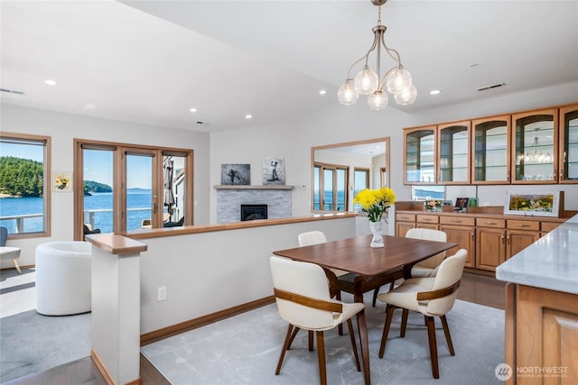 2401 Skyline Way Unit 203E, Anacortes, WA 98221 - dining space featuring a stone fireplace, plenty of natural light, recessed lighting, a water view, and a chandelier