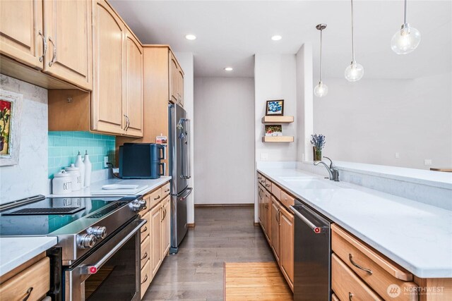 2401 Skyline Way Unit 203E, Anacortes, WA 98221 - kitchen with appliances with stainless steel finishes, light brown cabinets, tasteful backsplash, light wood-style flooring, and decorative light fixtures