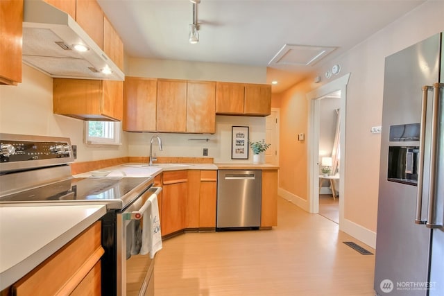 5618 35th Ave SW, Seattle, WA 98126 - kitchen with stainless steel appliances, under cabinet range hood, light countertops, and light wood-type flooring