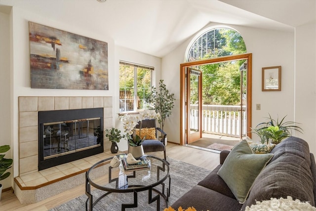 9004 20th Ave NE, Seattle, WA 98115 - living room with a tiled fireplace, vaulted ceiling, and wood finished floors