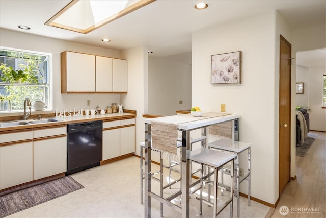 9004 20th Ave NE, Seattle, WA 98115 - kitchen with dishwasher, a skylight, recessed lighting, white cabinets, and light countertops