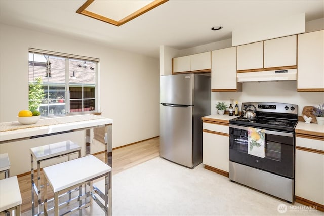 9004 20th Ave NE, Seattle, WA 98115 - kitchen with appliances with stainless steel finishes, under cabinet range hood, light countertops, and cream cabinets