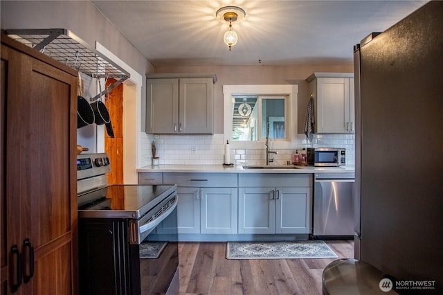 606 State St, Centralia, WA 98531 - kitchen featuring stainless steel appliances, gray cabinets, light wood-style floors, tasteful backsplash, and light countertops