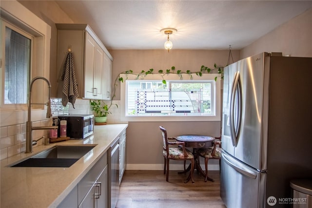 606 State St, Centralia, WA 98531 - kitchen with appliances with stainless steel finishes, light wood-style flooring, light countertops, and backsplash