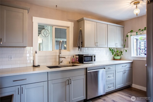 606 State St, Centralia, WA 98531 - kitchen with stainless steel appliances, light countertops, decorative backsplash, wood finished floors, and gray cabinets