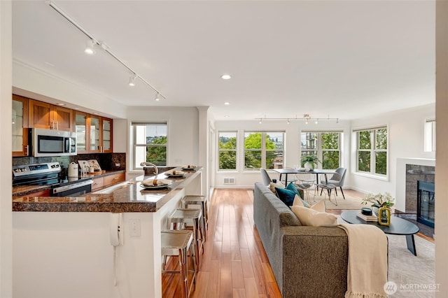 201 E Boston St Unit 2100, Seattle, WA 98102 - living area with rail lighting, light wood-style flooring, a glass covered fireplace, and recessed lighting