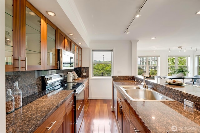 201 E Boston St Unit 2100, Seattle, WA 98102 - kitchen with stainless steel range with electric cooktop, brown cabinetry, track lighting, wood-type flooring, and plenty of natural light