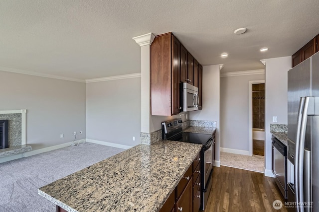 2514 57th Ave SW Unit 301, Seattle, WA 98116 - kitchen with stainless steel appliances, crown molding, a fireplace with raised hearth, light stone counters, and a textured ceiling
