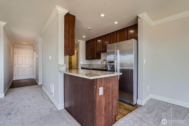 2514 57th Ave SW Unit 301, Seattle, WA 98116 - kitchen with stainless steel fridge, crown molding, dark brown cabinets, light stone counters, and light carpet
