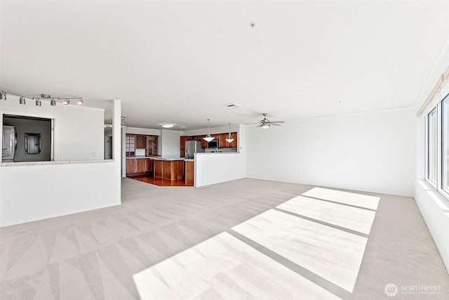 3201 Pacific Ave Unit 602, Tacoma, WA 98418 - unfurnished living room featuring carpet flooring, a ceiling fan, and rail lighting
