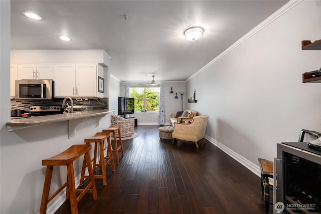 960 Harris Ave Unit 305, Bellingham, WA 98225 - kitchen with appliances with stainless steel finishes, a breakfast bar, decorative backsplash, open floor plan, and white cabinets