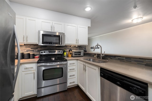 960 Harris Ave Unit 305, Bellingham, WA 98225 - kitchen featuring appliances with stainless steel finishes, backsplash, white cabinetry, light countertops, and ornamental molding