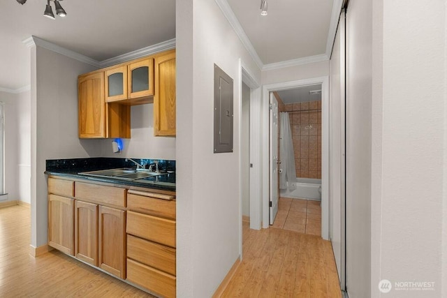 15146 65th Ave S Unit 518, Tukwila, WA 98188 - kitchen featuring ornamental molding, dark countertops, light wood-style floors, glass insert cabinets, and electric panel
