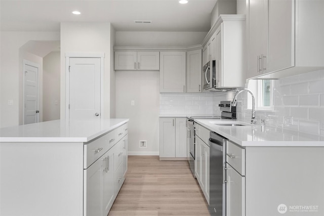 14756 88th Way SE Unit 10, Yelm, WA 98597 - kitchen with stainless steel appliances, light wood finished floors, decorative backsplash, a center island, and recessed lighting