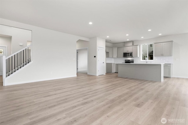 14756 88th Way SE Unit 10, Yelm, WA 98597 - unfurnished living room with light wood-type flooring, recessed lighting, and stairs